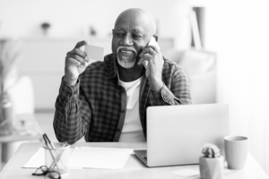 Older man holding a credit card while on the phone